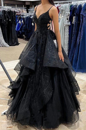 Black evening gown with intricate detailing in a store setting